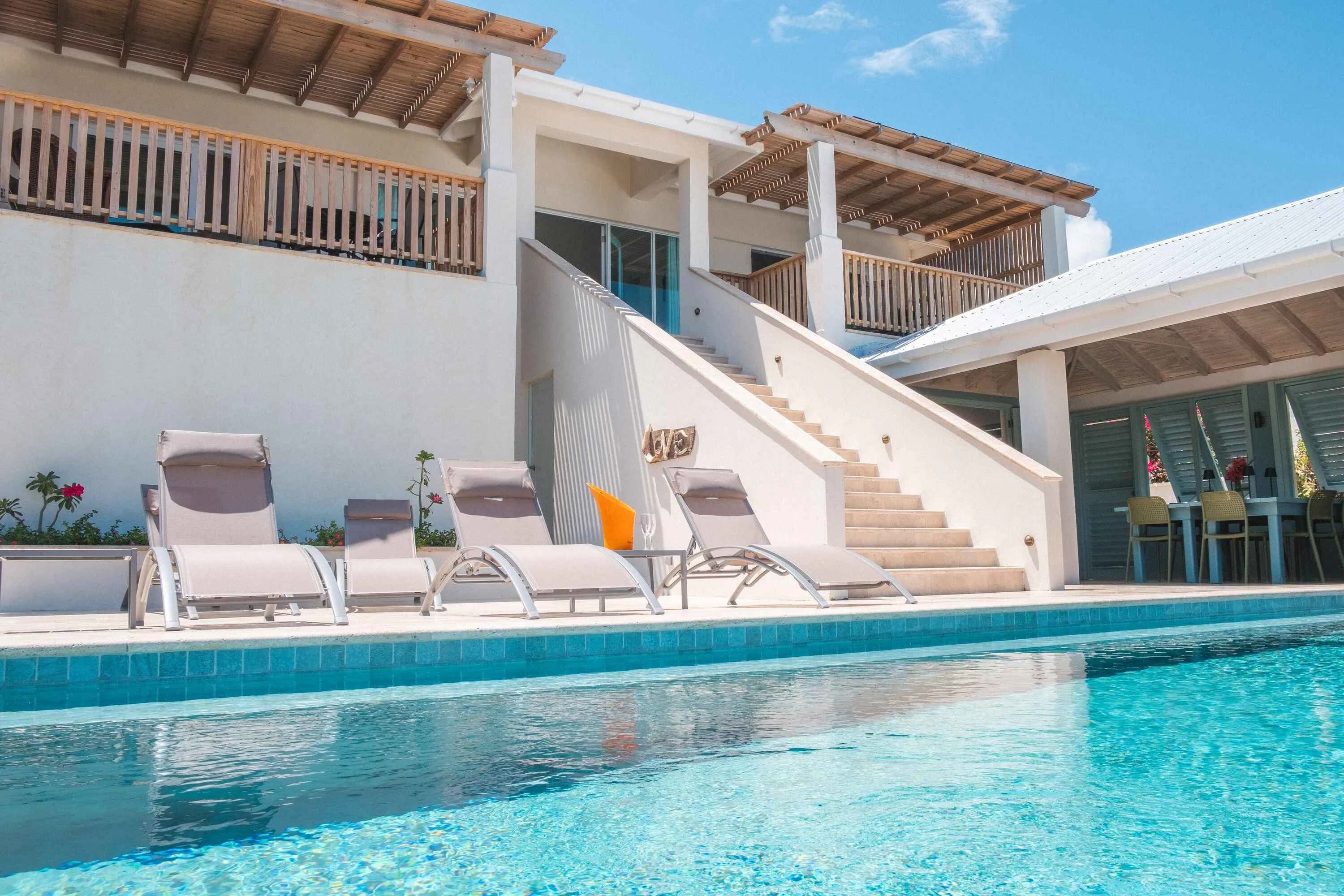 View of rear of property showing pool area and stairs up to two balcony areas and main living space.